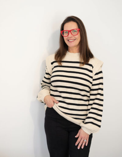 A woman poses for the camera with one hand on her hip and one on her thigh.