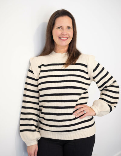 A woman poses for the camera with a hand on her hip.